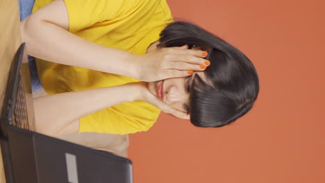Vertical-video-of-Young-woman-looking-at-laptop-gets-frustrated.